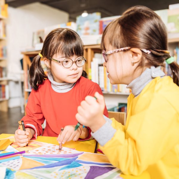 Young girl with down syndrome with friends in library