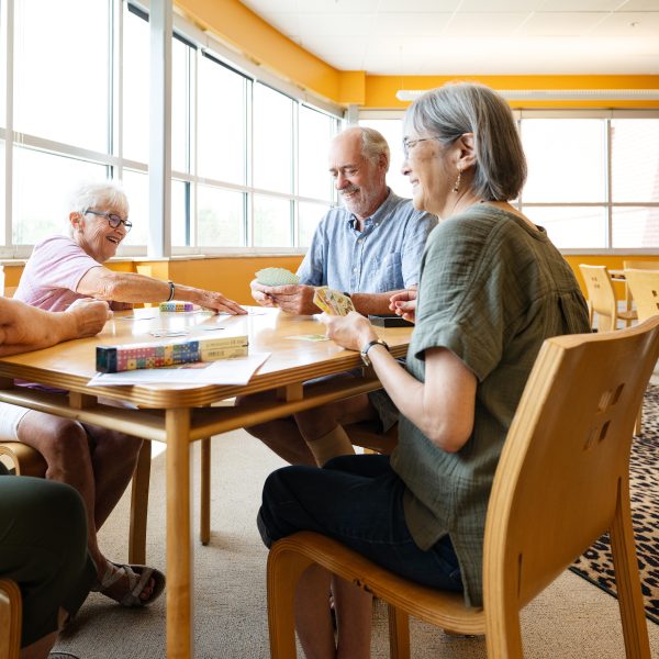 Seniors drinking coffee chatting in library