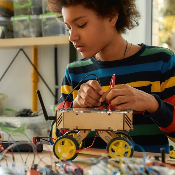 Young boy creating electric cart in maker's space