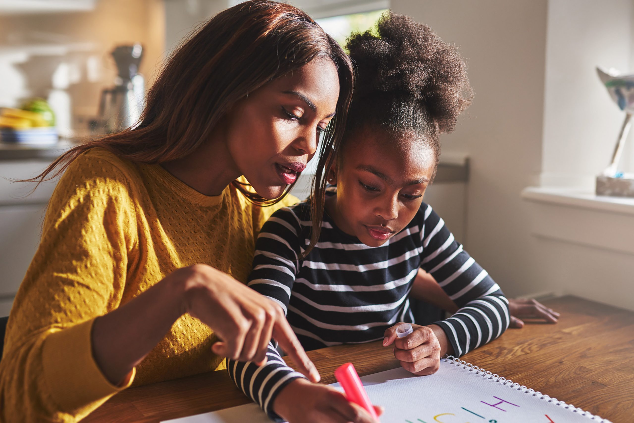 African American mentoring young girl in library