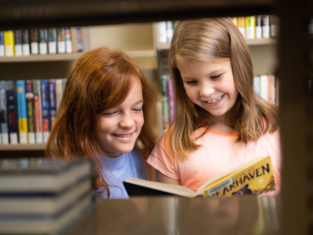 Two young girls in library